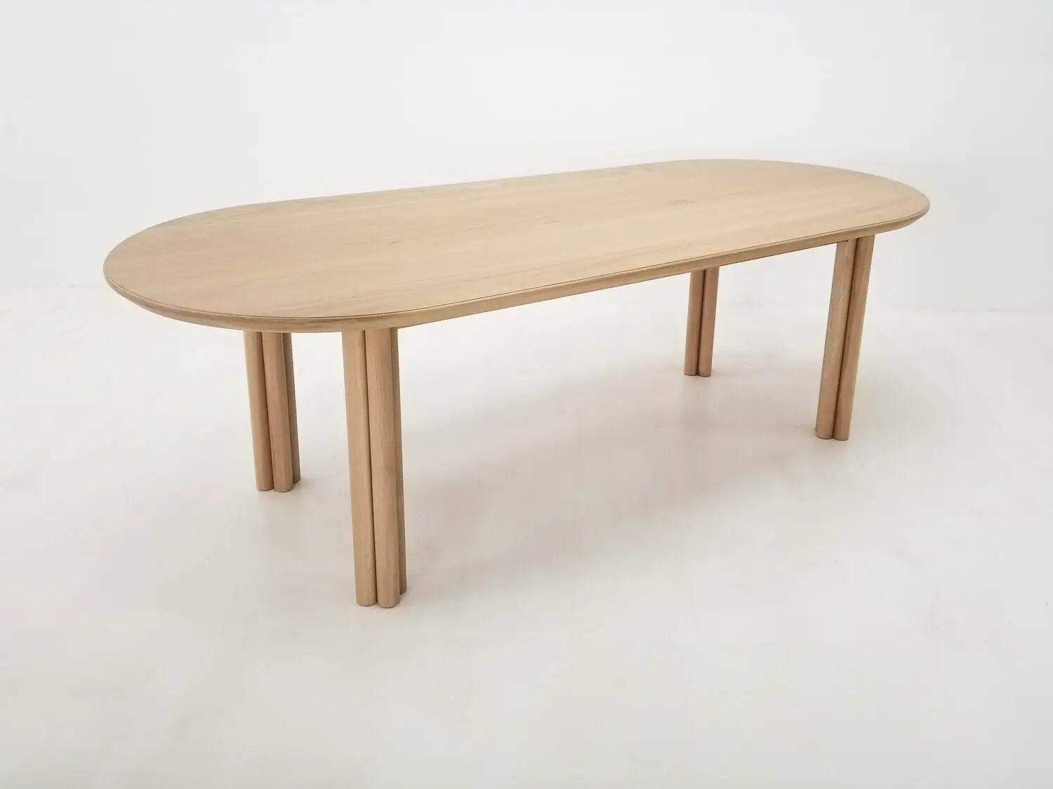 BEAU dining table in natural white oak with a 1⅜ inch thick oval top and clustered cylinder legs