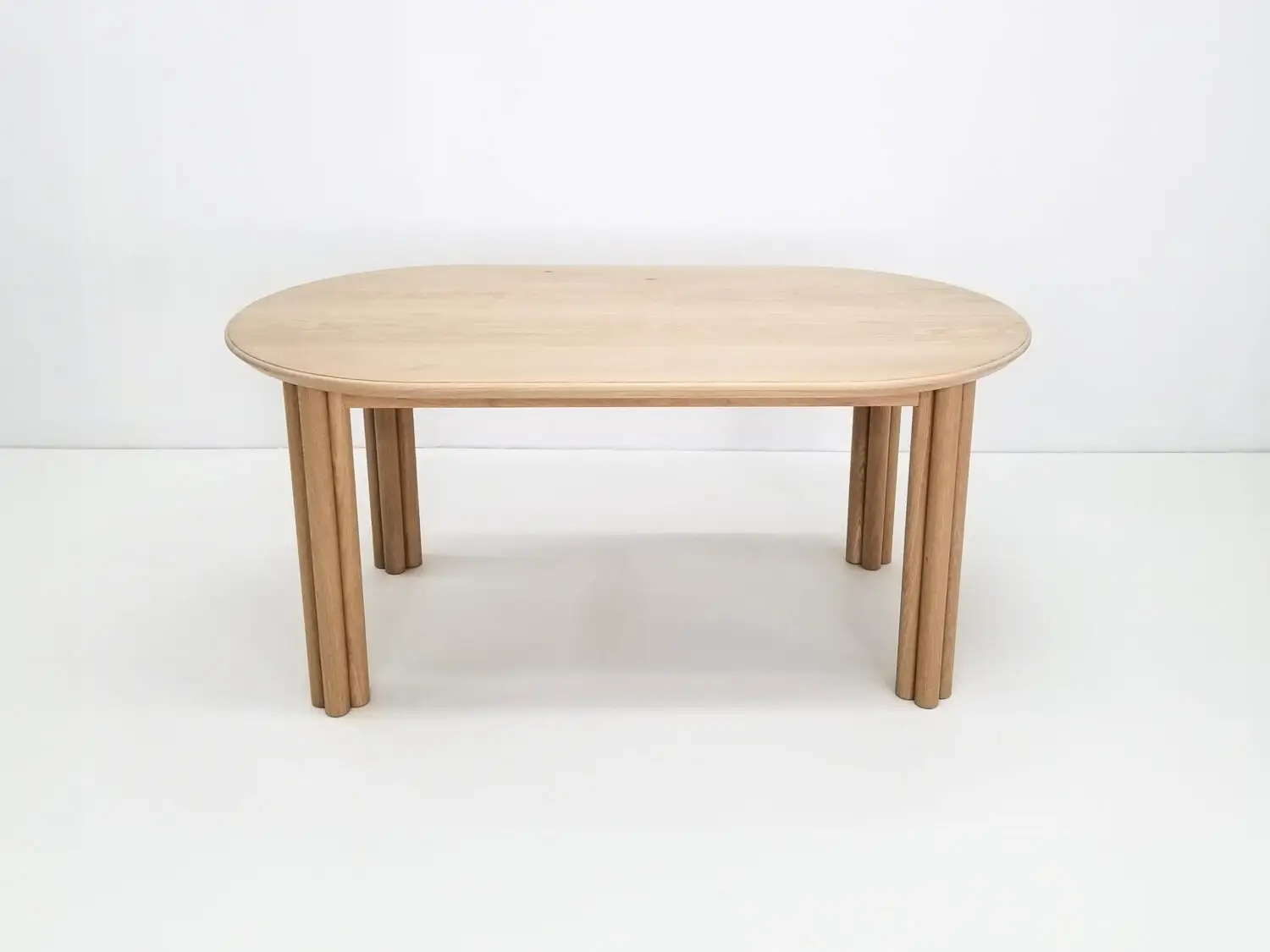 BEAU dining table in natural white oak with a 1⅜ inch thick oval top and clustered cylinder legs