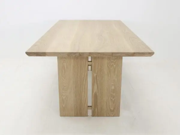 A close up of a panel table with split legs.