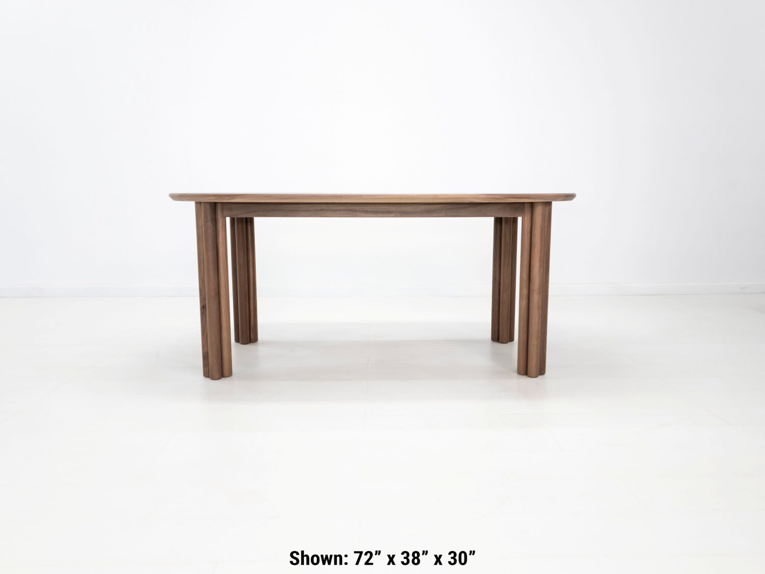 Handmade walnut dining table with soft sculpted edges and rounded legs