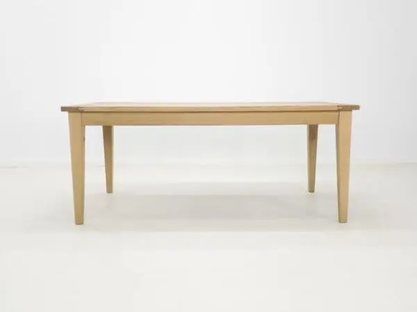 A white oak dining table with tapered legs.