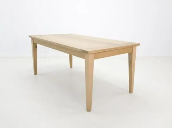 A white oak dining table with tapered legs.