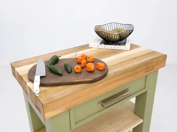 Green kitchen island with peppers and knife.