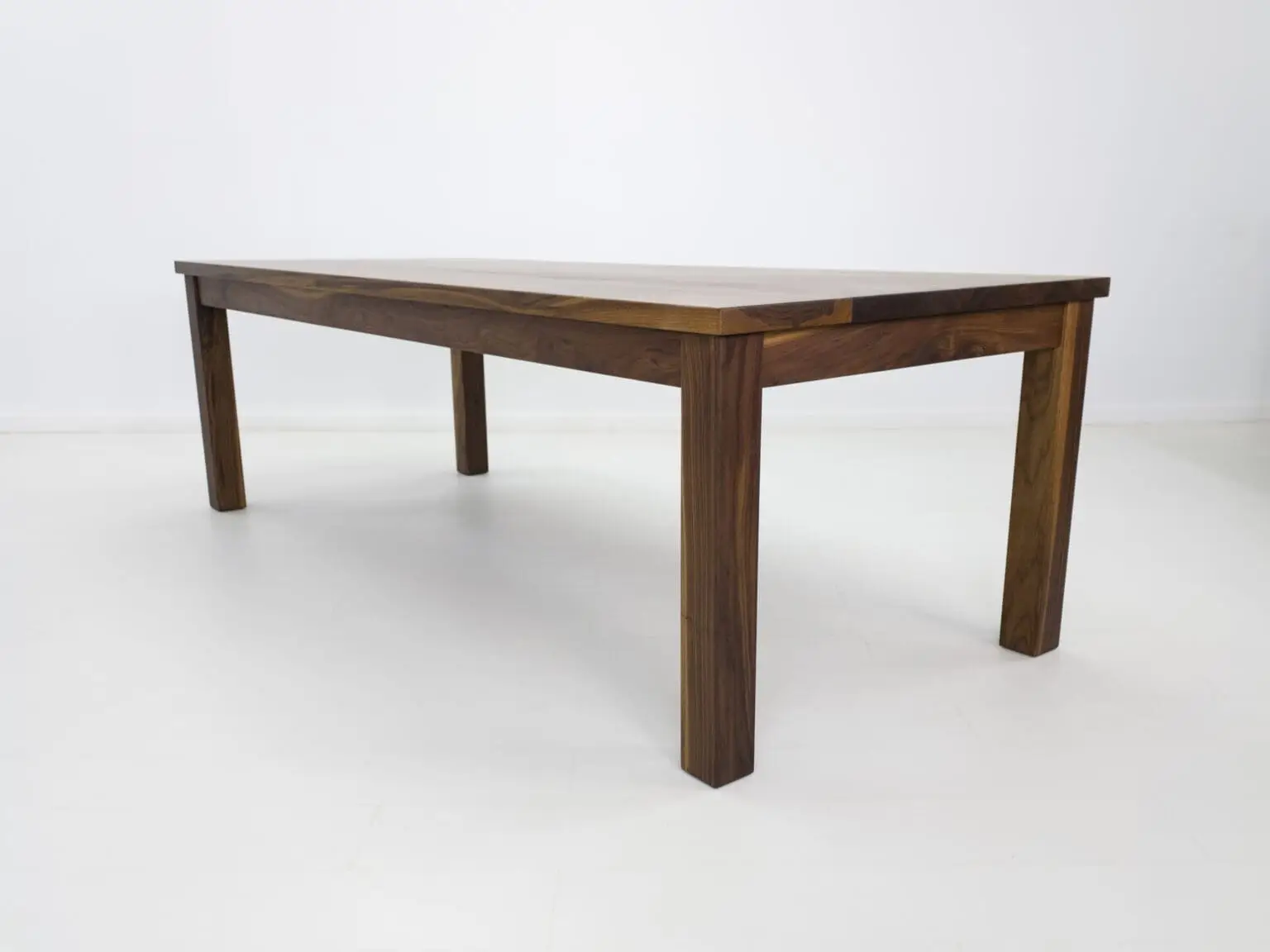 A parsons style walnut dining table