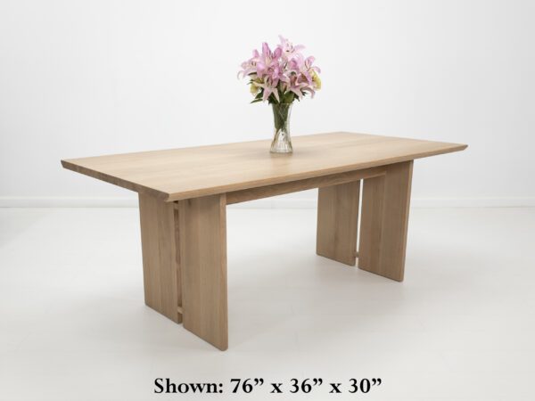 A split leg dining table with flowers on top.