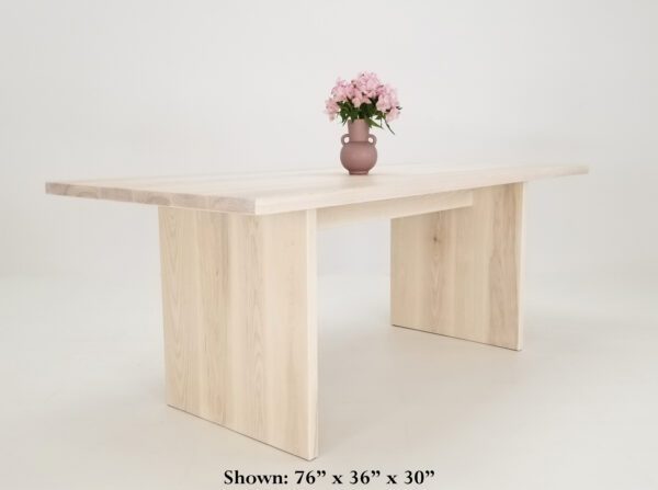 A panel dining table with a vase on top.