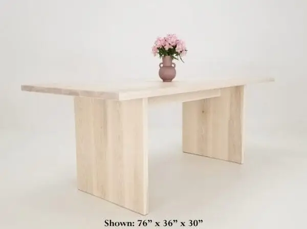 A panel dining table with a vase on top.