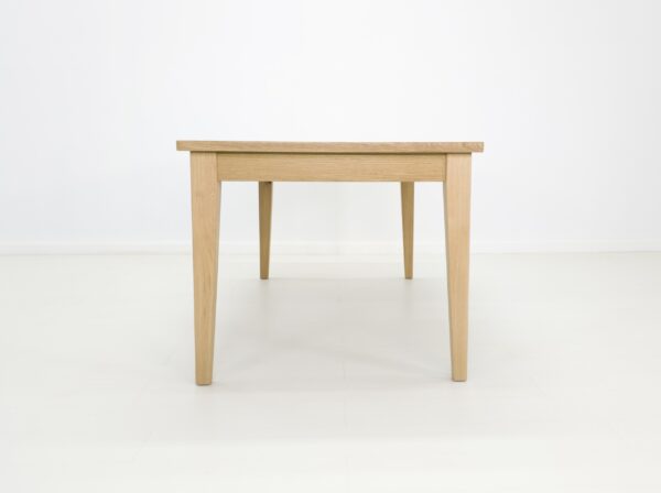 A white oak dining table with tapered legs.