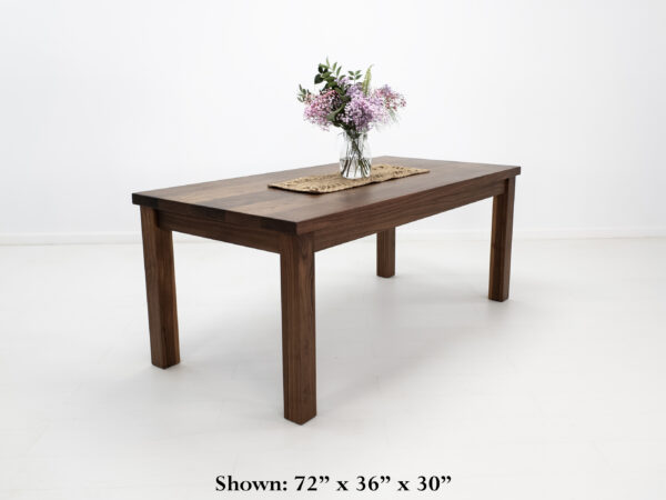 A walnut dining table with decor on top of it.