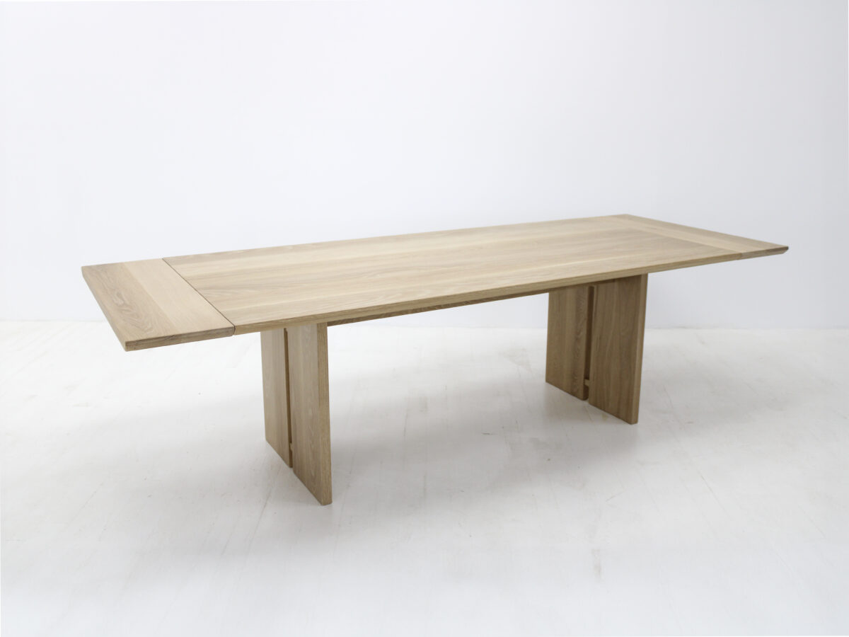 Side view of the DIVI dining table highlighting the beveled edge and natural wood grain finish