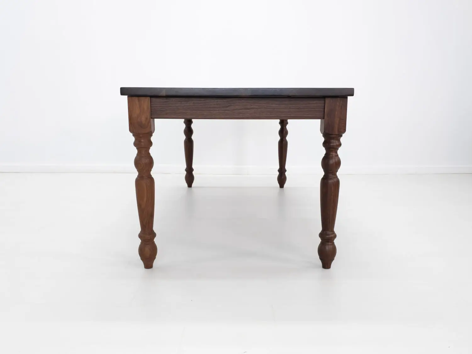 Traditional farmhouse style TESS table with turned legs designed to be a timeless centerpiece in any dining space