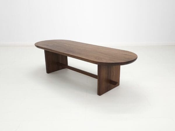 A solid walnut trestle coffee table.