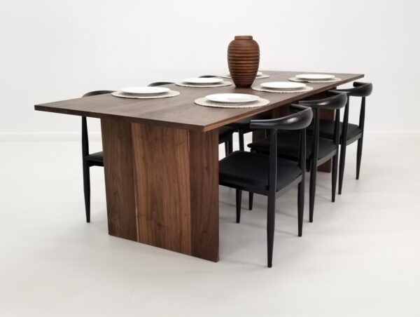 A walnut dining table with seating around it.