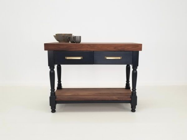 A walnut butcher block kitchen island with mugs and bowl on top of it.