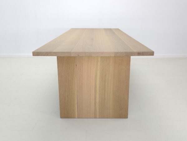 A close up of a white oak panel dining table.