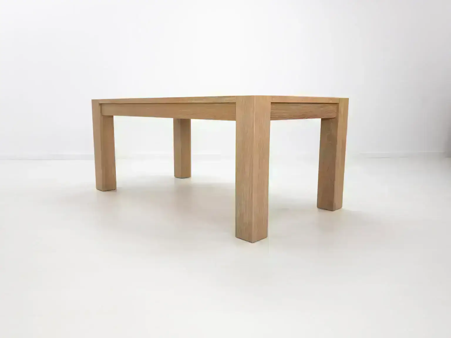 JAQI dining table in seawashed white oak finish featuring a seamless top with breadboard ends