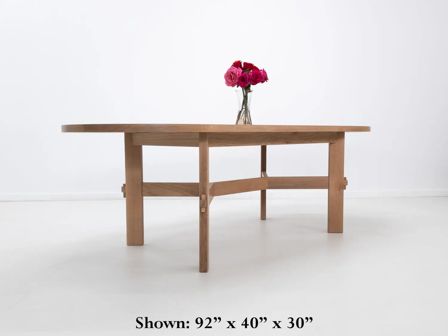 Custom COLT dining table with solid rectangular legs and a striking angular stretcher design