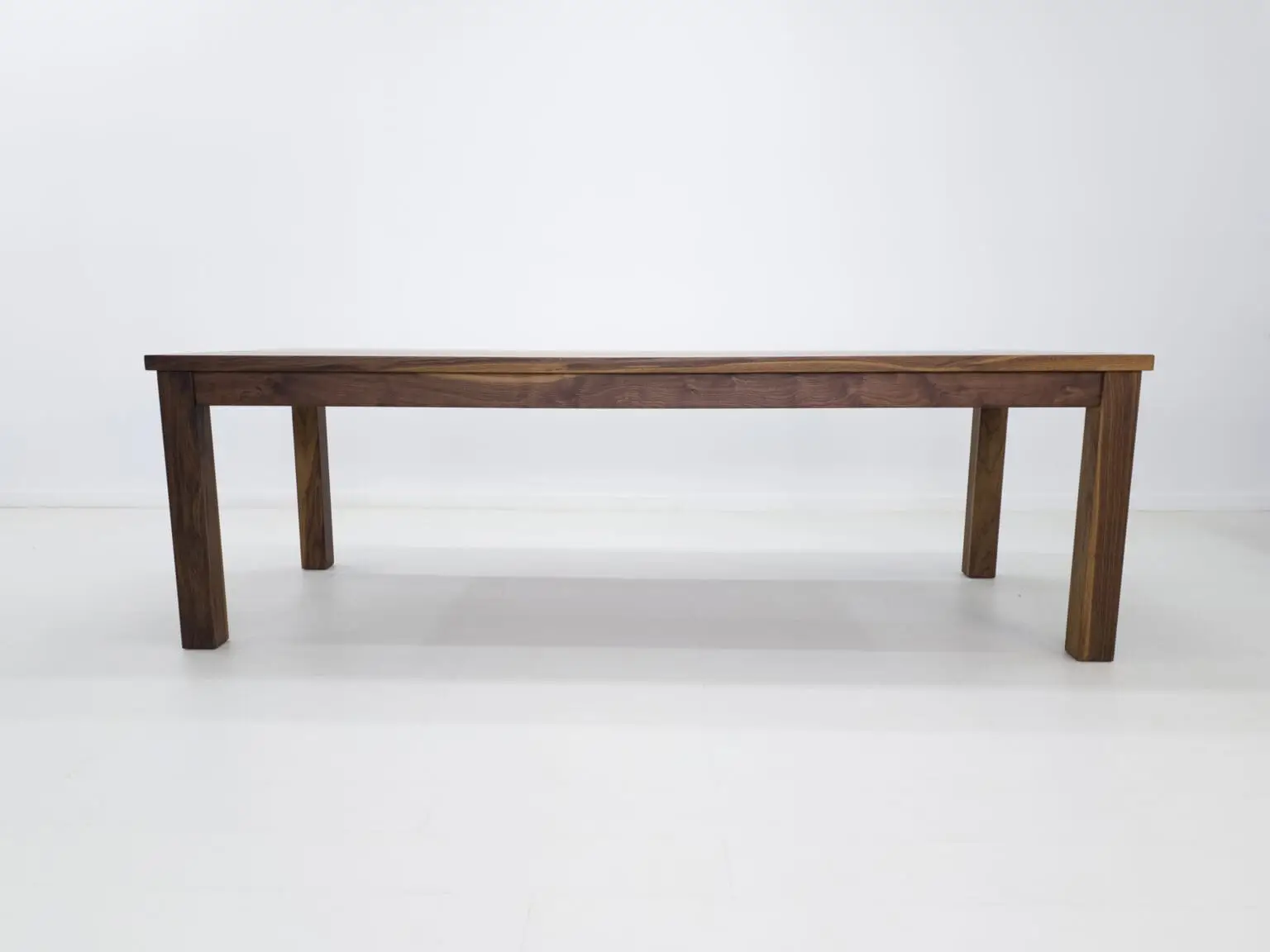 A parsons style walnut dining table