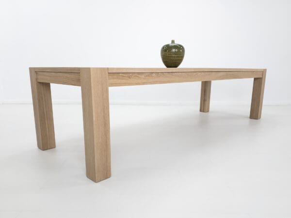 A white oak, square leg dining table with a cerused finish.