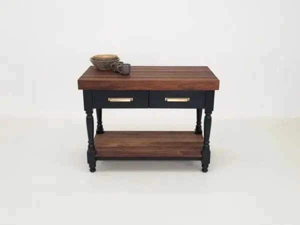 A walnut butcher block kitchen island with mugs and bowl on top of it.