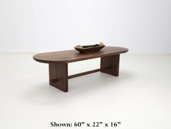 A solid walnut trestle coffee table.