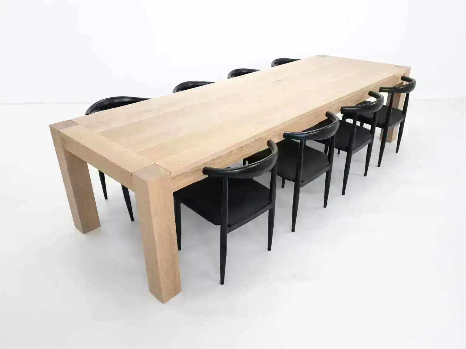 JAQI dining table in seawashed white oak finish featuring a seamless top with breadboard ends