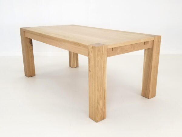 A JAQI Colossal Leg Parsons Dining Table with two legs on a white background.