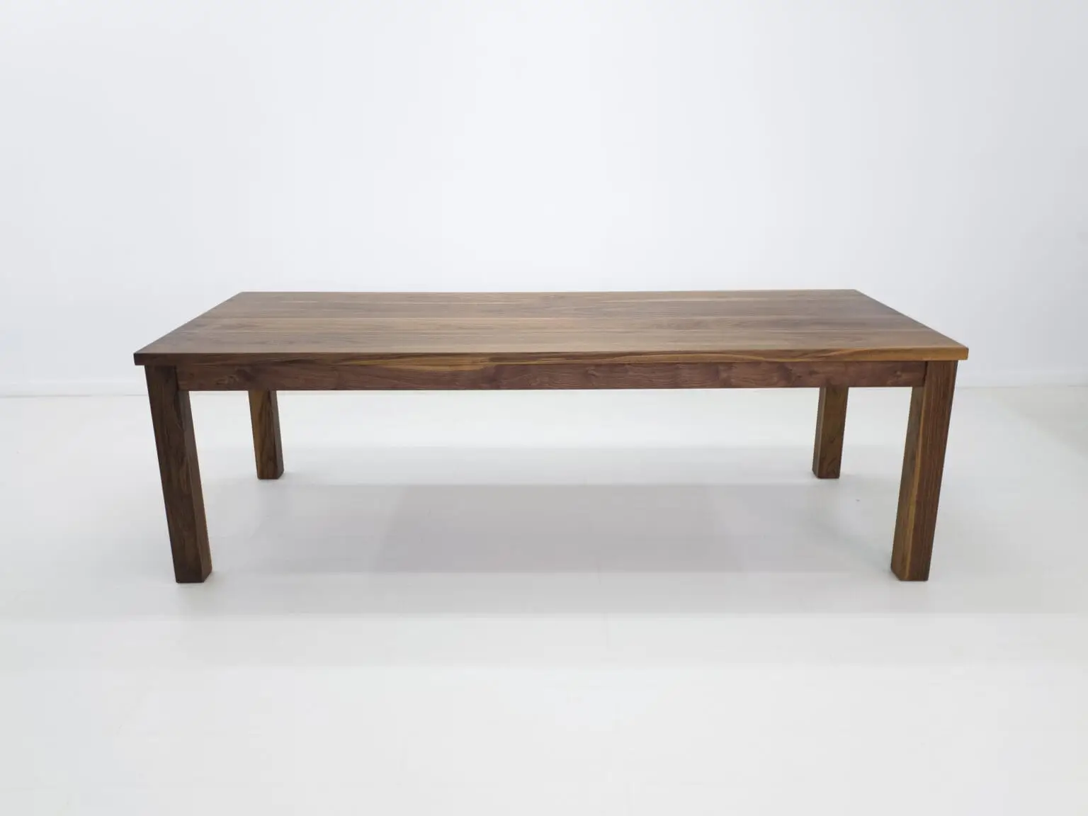 A parsons style walnut dining table