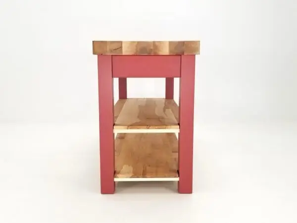 Red kitchen island with wood shelves.