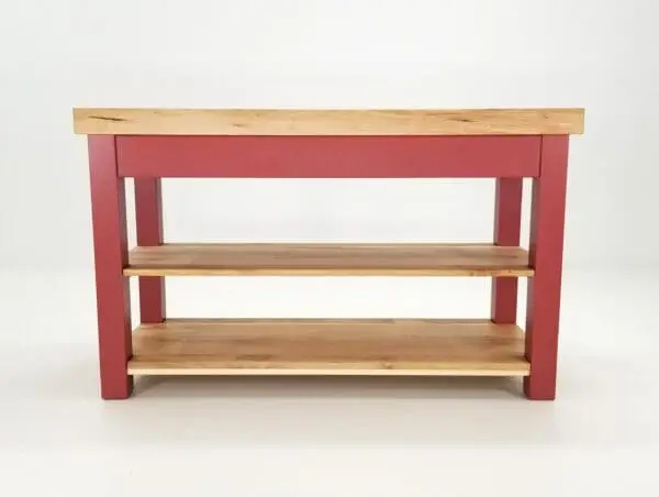 Red wooden table with two shelves.