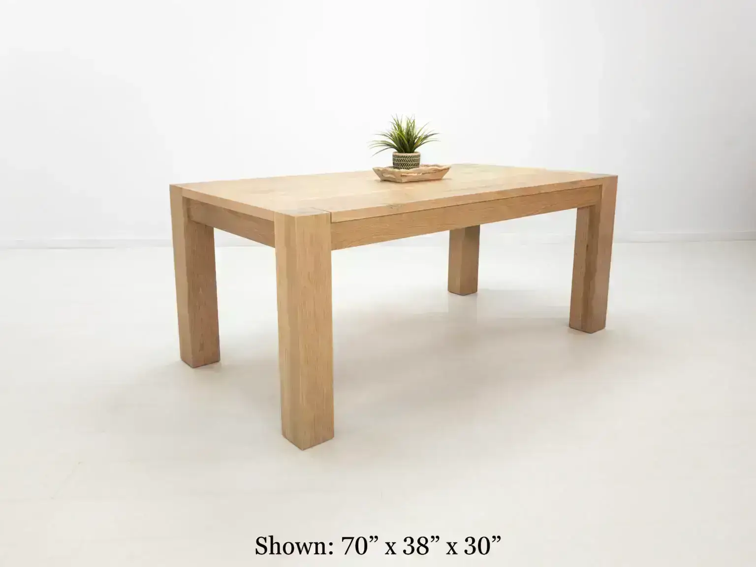 JAQI dining table in seawashed white oak finish featuring a seamless top with breadboard ends