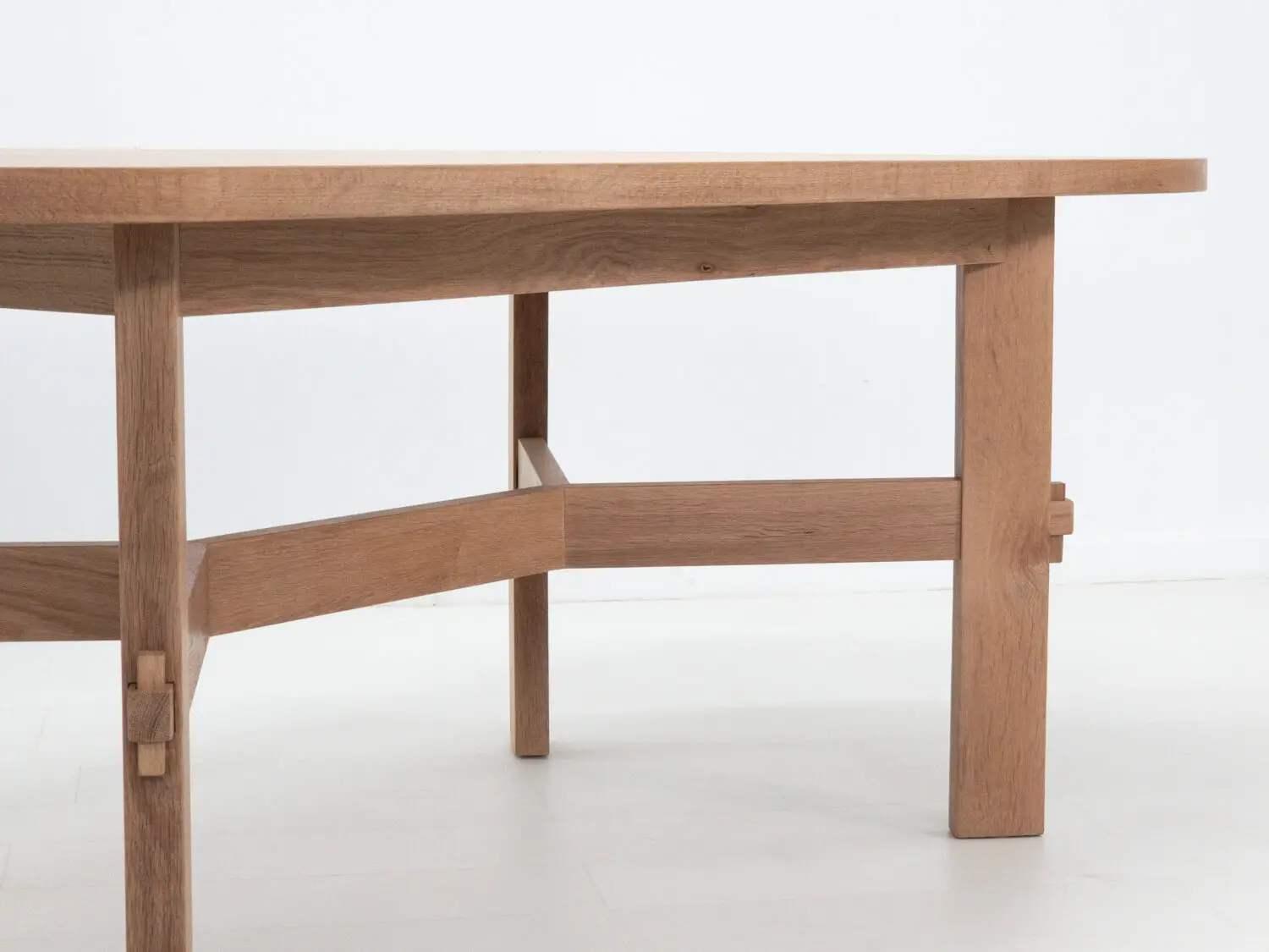 COLT dining table crafted from solid white oak with an oval top and angular stretcher base