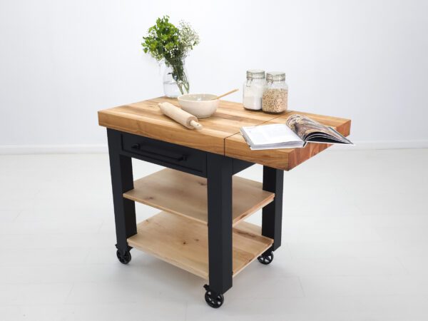 A butcher block cart with a drop leaf extension and baking items on top of it.