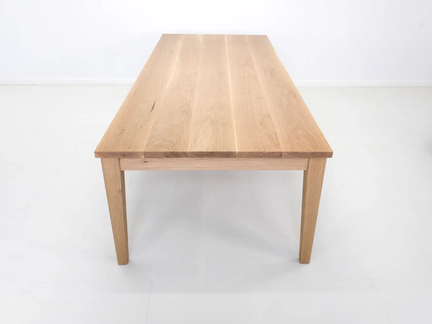 ARAN dining table in white oak with seamless plank top and tapered legs