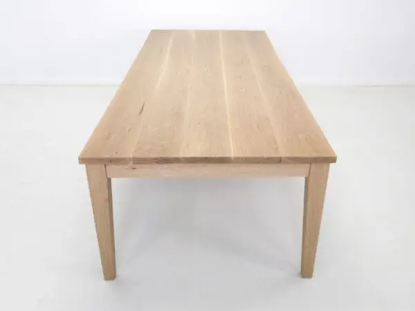 Wooden dining table with tapered legs.