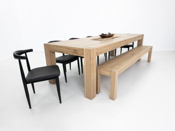 A white oak dining table with seating around it.