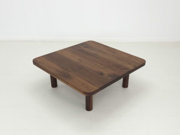 A walnut coffee table with four legs.