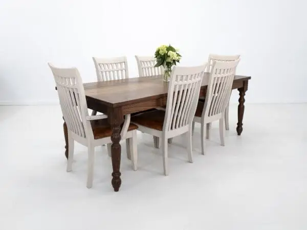 A turned leg dining table with flowers on top and seating around.