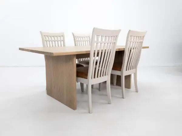 A white oak LILY dining table with a 1.5" thick table top and chairs around it.