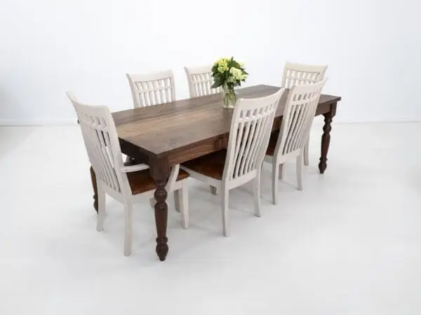 A turned leg dining table with flowers on top and seating around.