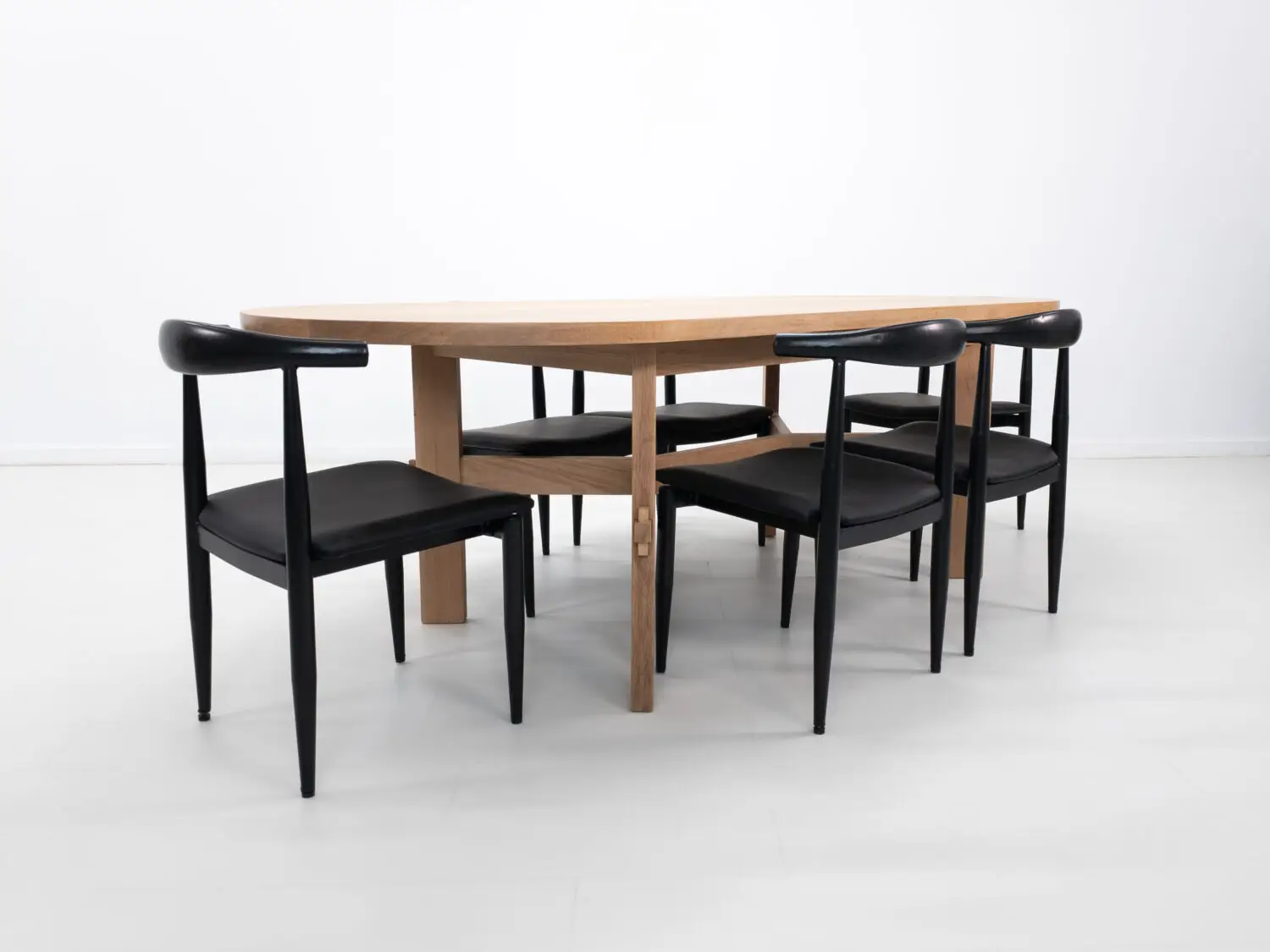 Custom COLT dining table with solid rectangular legs and a striking angular stretcher design