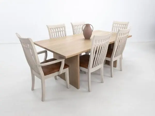 A white oak LILY dining table with a 1.5" thick table top and chairs around it.