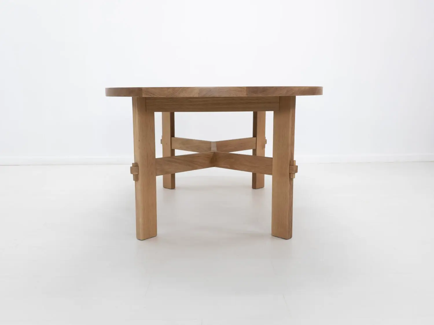 COLT dining table crafted from solid white oak with an oval top and angular stretcher base