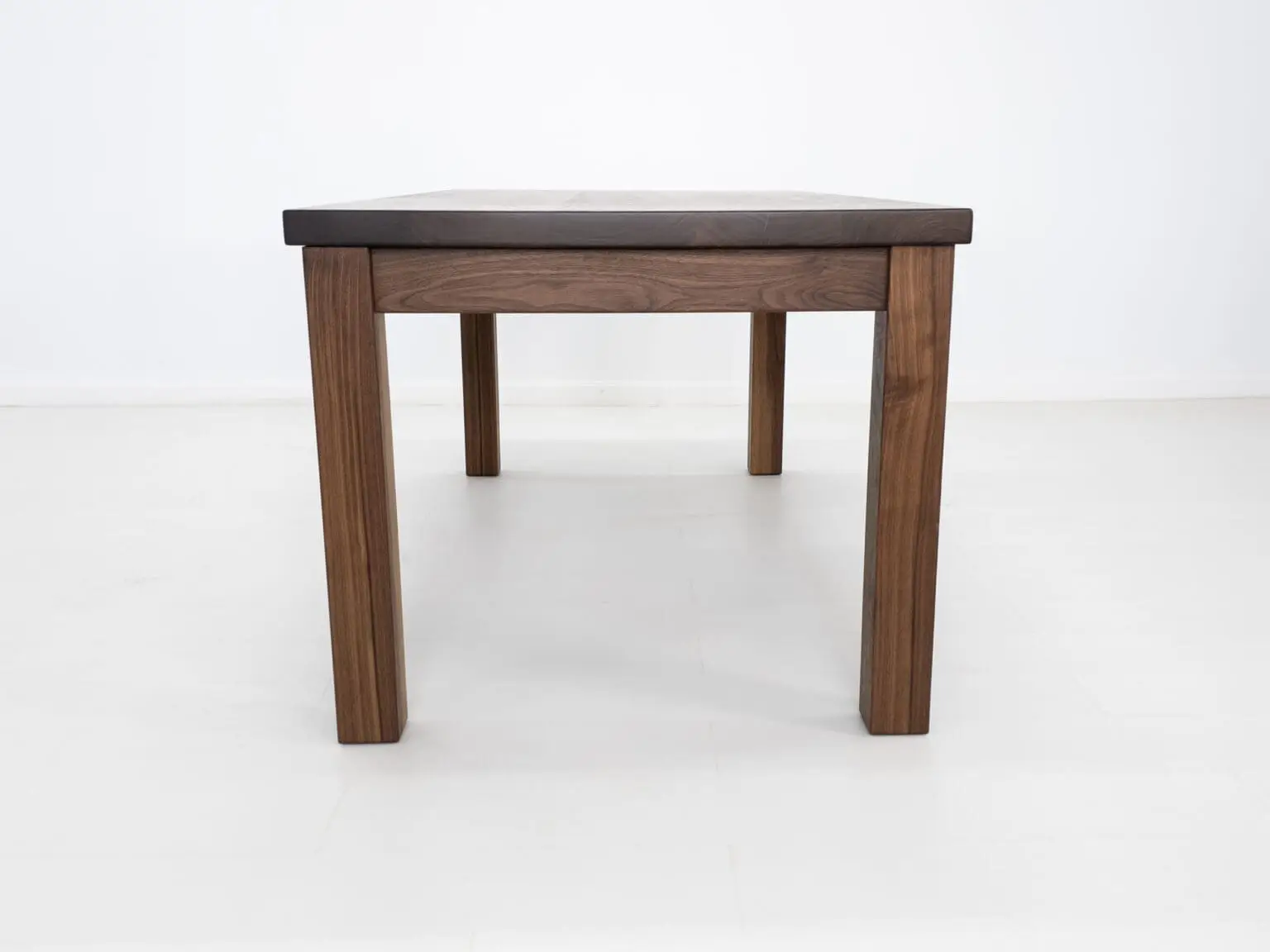 A parsons style walnut dining table