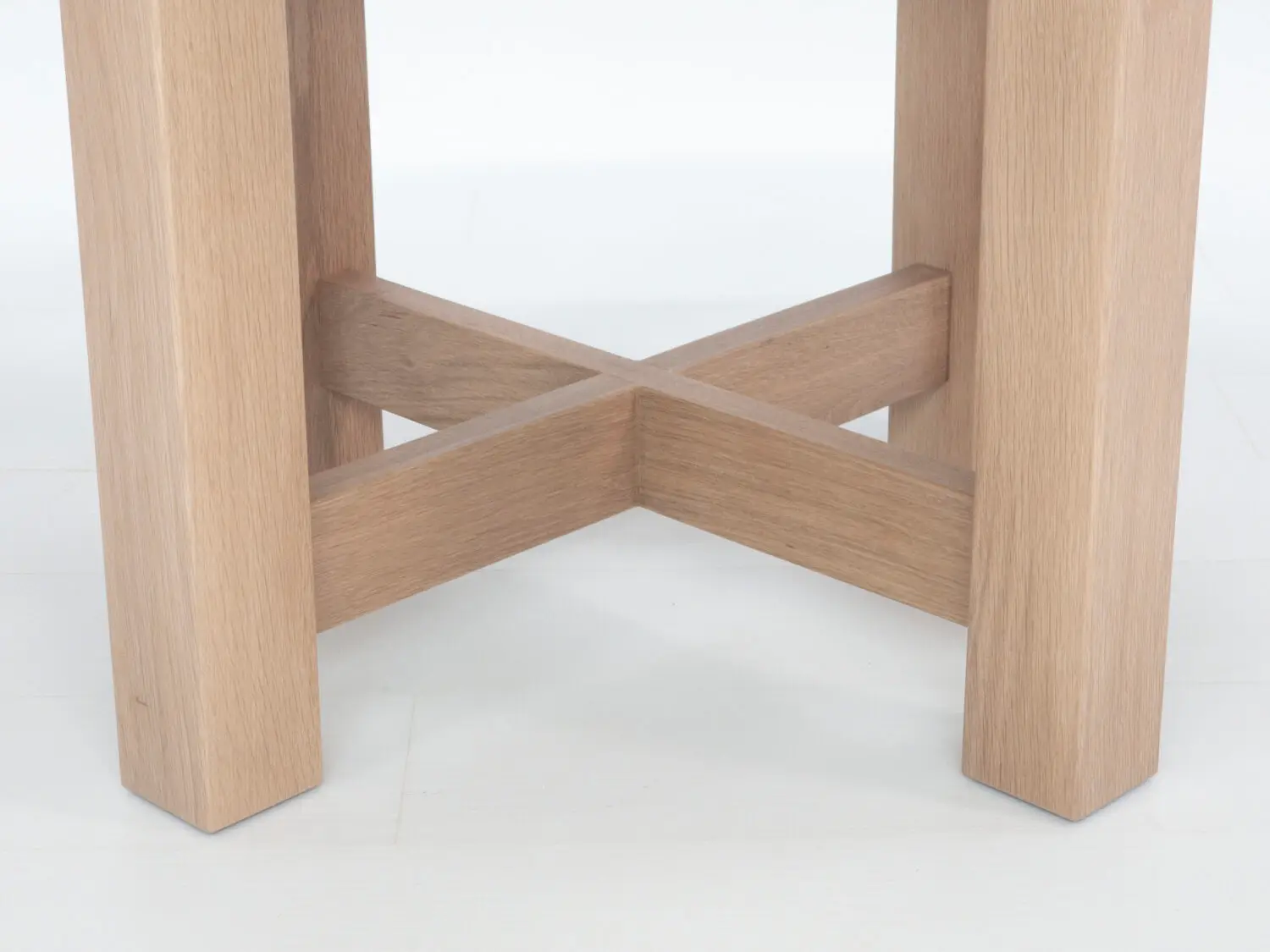 Close up of OTTO dining tables thick round top showcasing premium hardwood grain