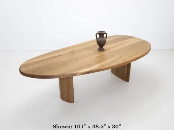 A freeform dining table with decor on top of it.