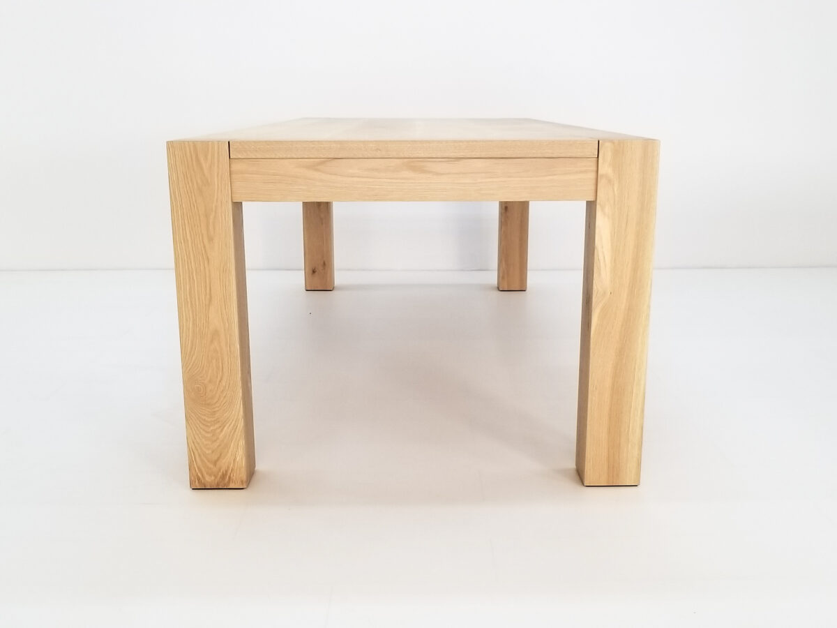 Colossal leg JAQI dining table in natural white oak showcasing its clean lines and sturdy design