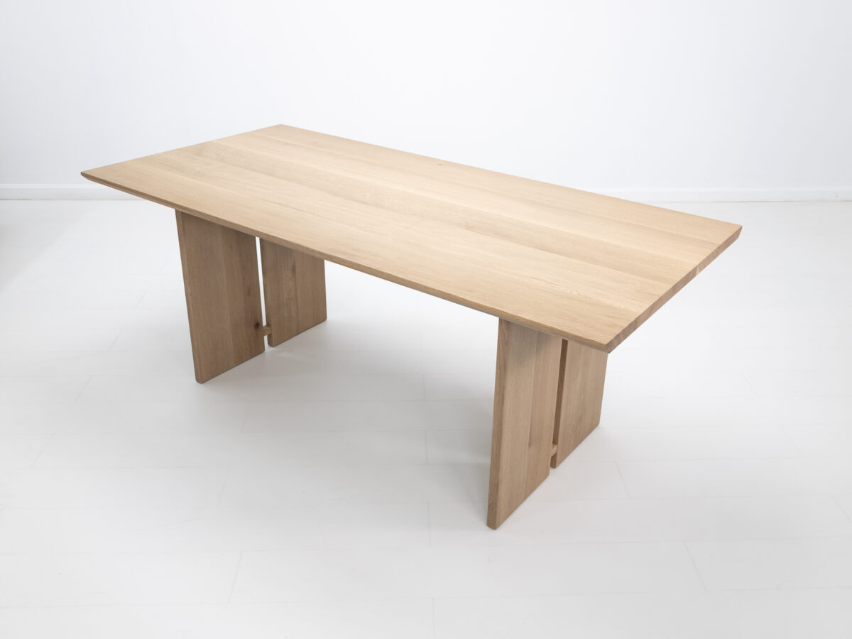 Side view of the DIVI dining table highlighting the beveled edge and natural wood grain finish