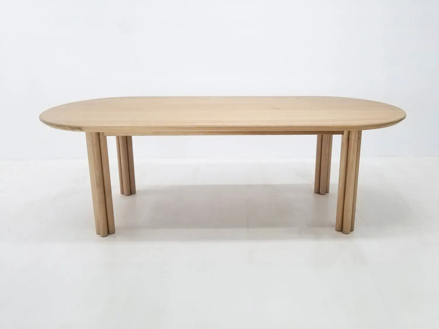 BEAU dining table in natural white oak with a 1⅜ inch thick oval top and clustered cylinder legs