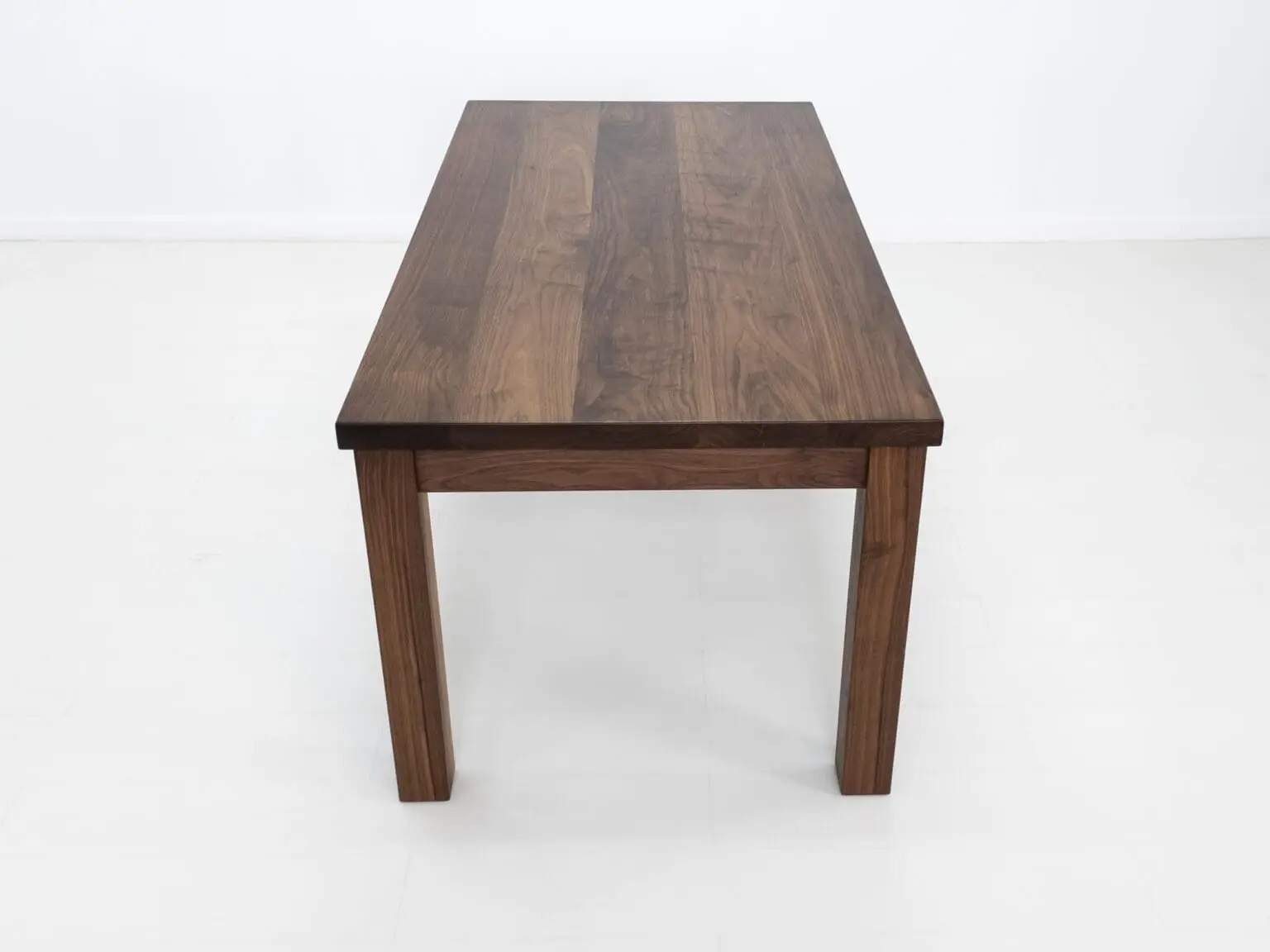 A parsons style walnut dining table